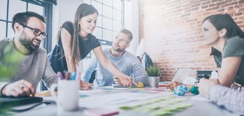 group of people working at a desk with notes and coffee