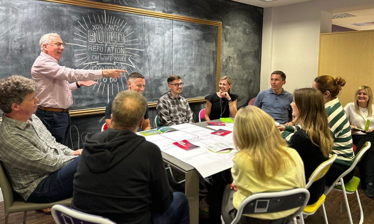 group of Fifth Ring employees working around a table